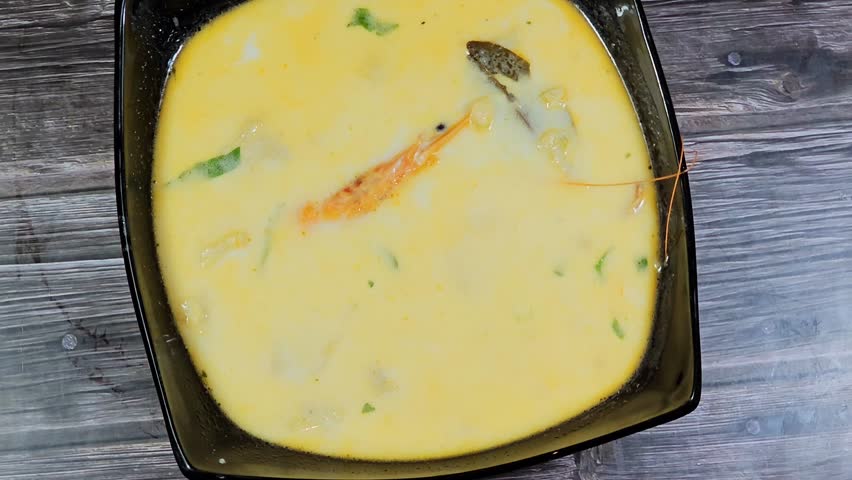 assorted seafood creamy soup of shrimps, squid, crabs, fish fillet, herbs, dill, garlic and onion, seafood mixture hot soup, healthy food concept of pieces of various sea food, selective focus