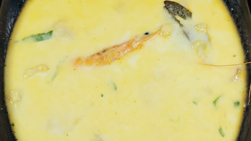 assorted seafood creamy soup of shrimps, squid, crabs, fish fillet, herbs, dill, garlic and onion, seafood mixture hot soup, healthy food concept of pieces of various sea food, selective focus