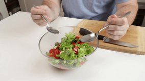 A man prepares a salad, mixes vegetables in a bowl, domestic adult male, healthy eating, fresh produce  - Powered by Shutterstock - Get 15% off with code: PIKWIZARD15