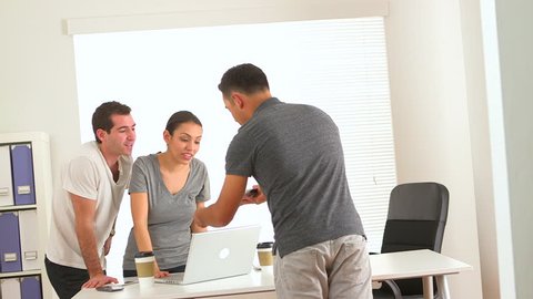 Hispanic business man sharing tablet with coworkers