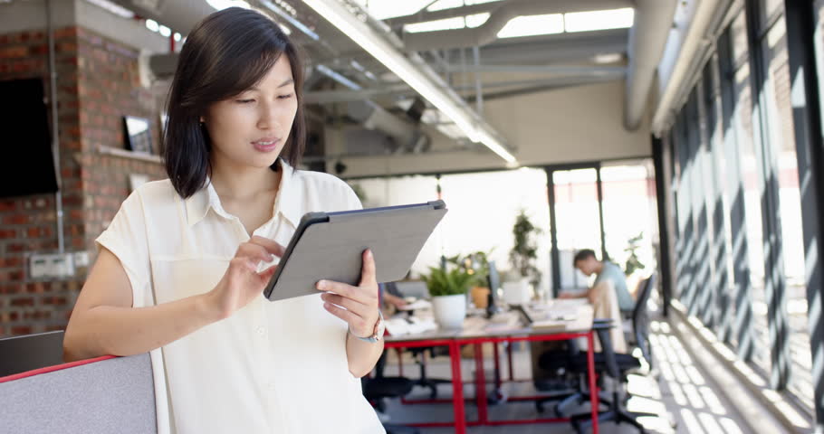 Holding tablet, asian woman planning interior design in modern office workspace, copy space. technology, creativity, professional
