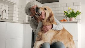 Cheerful Elderly Lady Having Fun With Her Lovely Golden Retriever Dog In The Kitchen - Powered by Shutterstock - Get 15% off with code: PIKWIZARD15