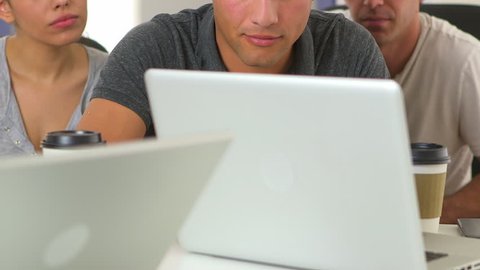 Close up of Hispanic and Caucasian office workers at laptop