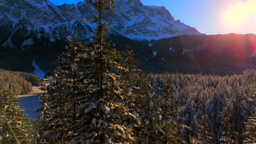 Breathtaking aerial view over snow-covered treetops in Germanys Bavarian Alps, showcasing Zugspitze massif. Zugspitze Gipfel highest peak of Wetterstein Mountains and highest mountain in Germany. 