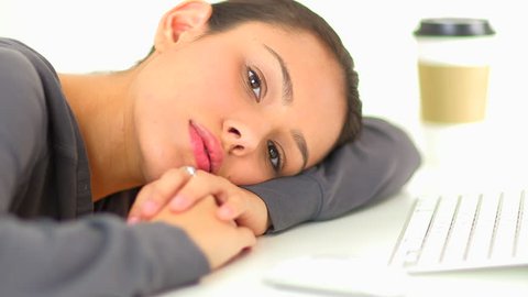 Latino business woman resting head on desk