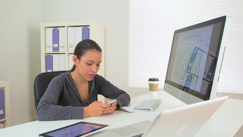 Happy Mexican business woman excited at desk