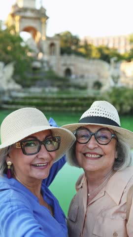 Senior tourists taking selfies in parc de la ciutadella, barcelona