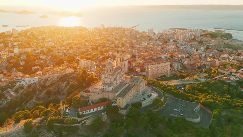 Aerial view of the Notre Dame de la Garde or Our Lady of the Guard church at sunset, southern France. The warm summer evening light illuminates the Marseille cityscape. 