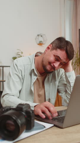 Bored sad upset tired exhausted photographer male freelancer fatigued unmotivated man manager disinterested boring laptop work editing photos, lazy thinking boredom working burnout at home office.