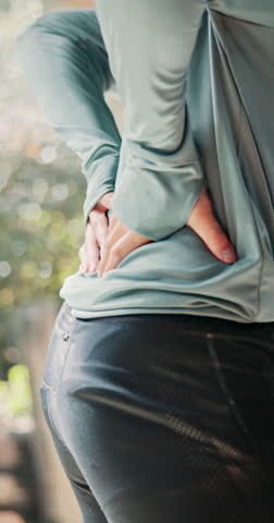 Back pain, hands and person in home, sore and injury on spine with tension, inflammation and muscle. Accident, workout and athlete with ache, body and uncomfortable with sprain, posture and hurt