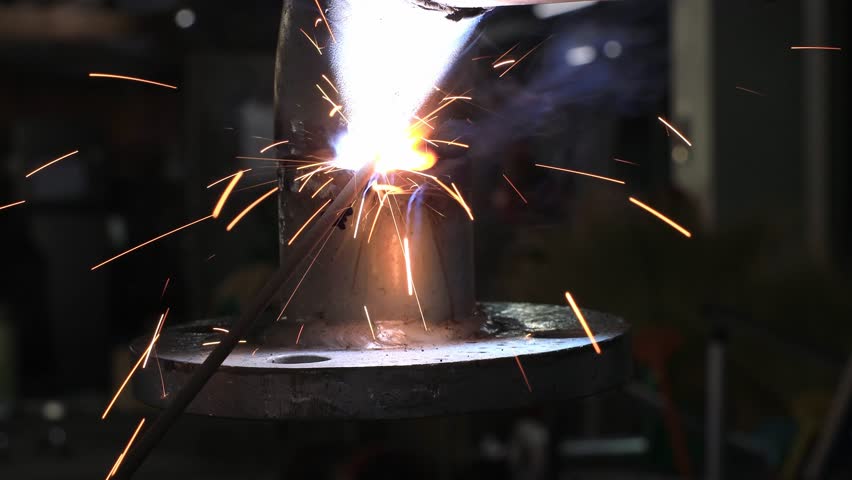 Welder Working on Metal Pipes in Workshop
