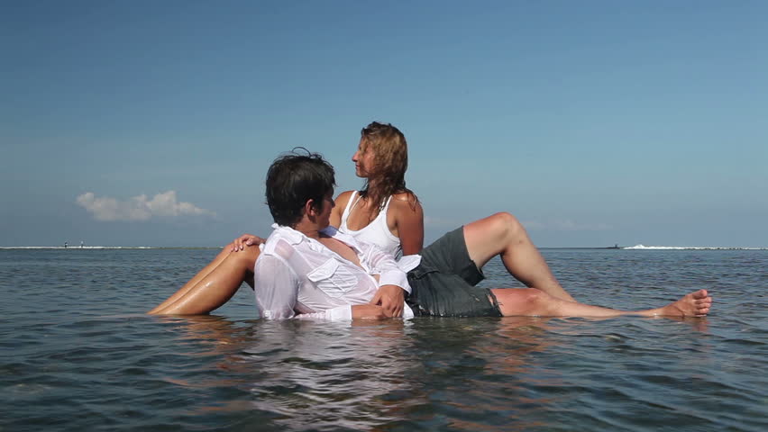 Cheerful attractive couple relaxing in water