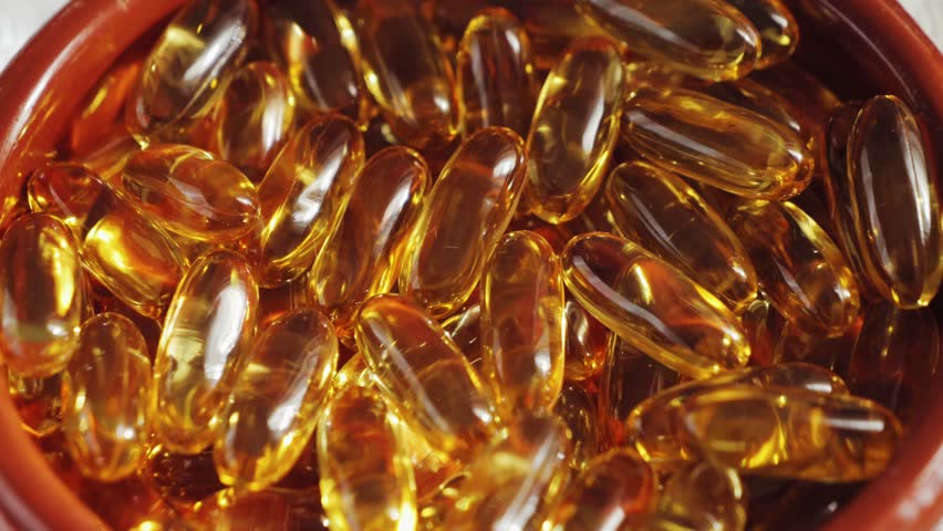 Omega 3 gold fish oil capsules. A natural capsules texture. Healthy lifestyle concept. High quality 4k footage