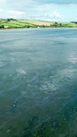 Explore the tranquil river landscape with rolling hills and dramatic cloud formations in a tranquil outdoor setting.