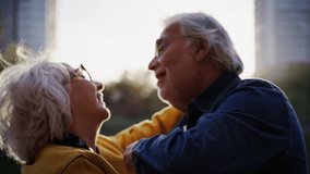 Cheerful mature adult marriage celebrate with dancing holding hands in middle of lake park city. Funny happy elder Caucasian couple enjoy vacation. Pensioner people in love enjoying life relationships - Powered by Shutterstock - Get 15% off with code: PIKWIZARD15