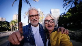 Caucasian smiling pensioners in love couple doing a video call selfie hugging together outdoors. Happy romantic adult people embracing. Grandparents look camera affectionate enjoying retirement time - Powered by Shutterstock - Get 15% off with code: PIKWIZARD15