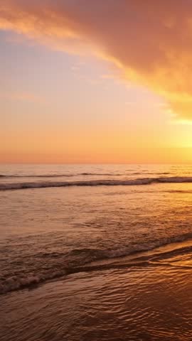 Atlantic ocean sunset with surging waves with people silhouettes at Fonte da Telha beach, Costa da Caparica, Portugal