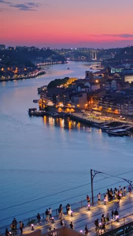 View of illuminated Porto city and Douro river and Dom Luis bridge I from famous tourist viewpoint Miradouro da Serra do Pilar in evening twilight with metro tram. Porto, Vila Nova de Gaia, Portugal