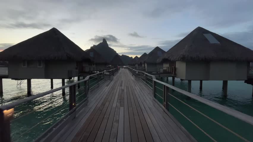 Cycling along the wooden walkway between water villas in Bora Bora
