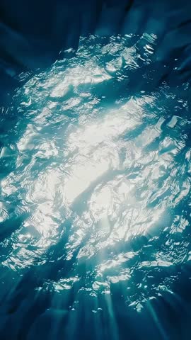 The mesmerizing underwater light reflects beautifully on the surface of the ocean