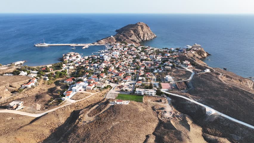 Aerial drone cinematic video of picturesque and historic main village of Psara island featuring landmark church of Saint Nikolas, North Aegean islands, Greece