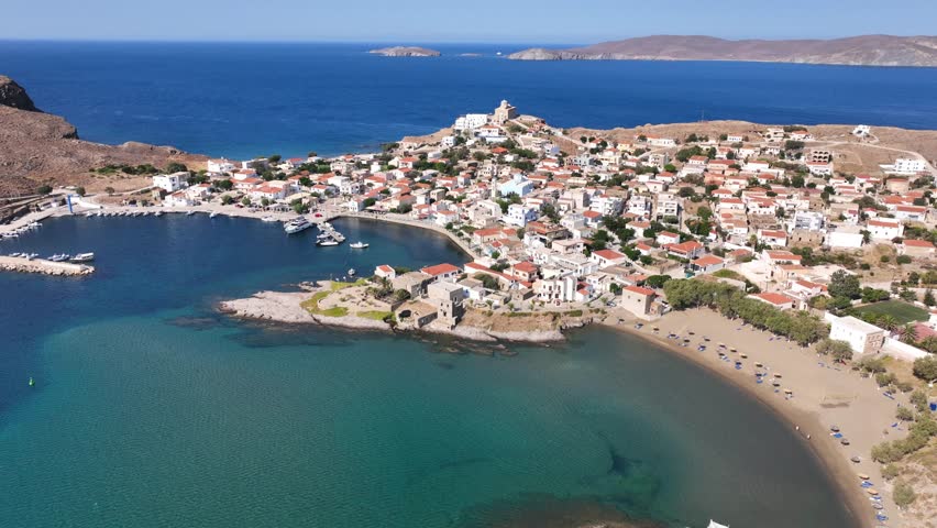 Aerial drone cinematic video of picturesque and historic main village of Psara island featuring landmark church of Saint Nikolas, North Aegean islands, Greece