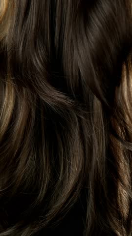 Super slow motion of wavy brown hair in detail. Filmed on high speed cinema camera, 1000 fps. Vertical aspect ratio.