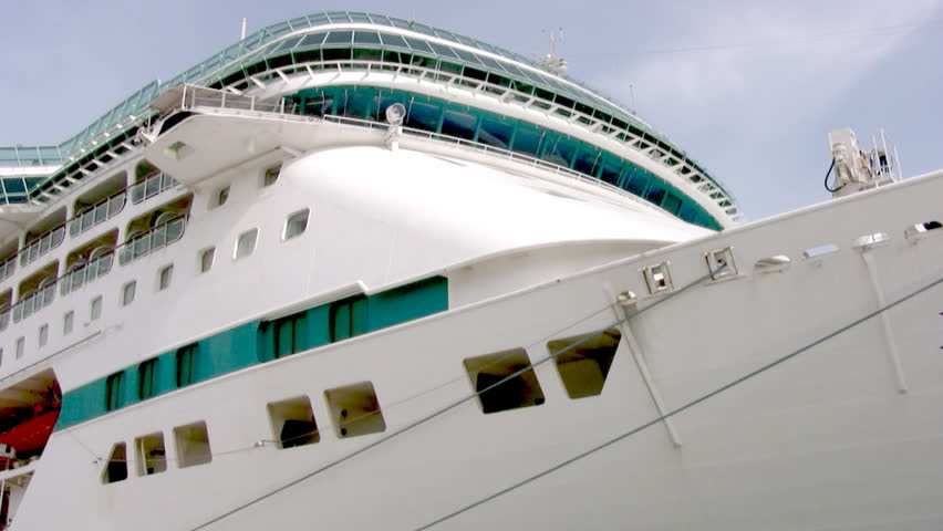 The camcorder carries along the side of a large snow-white cruise ship from stem