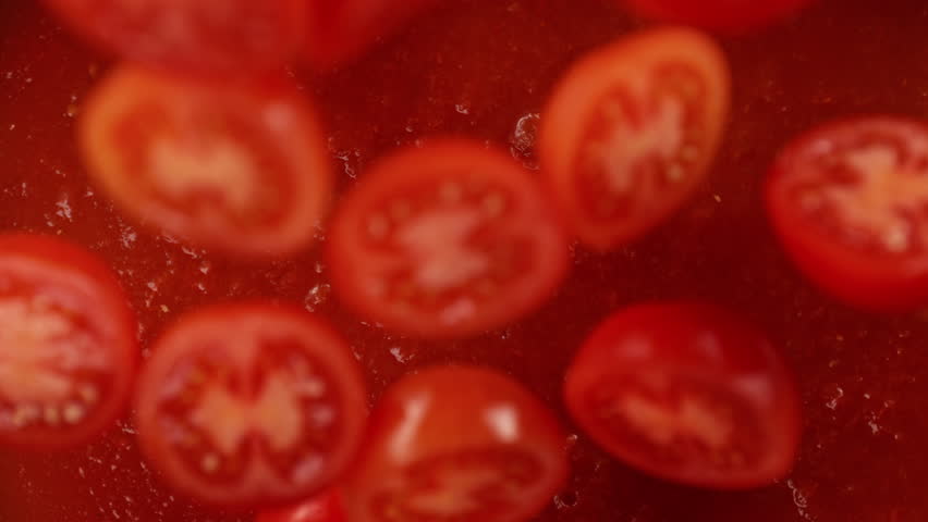 Super Slow Motion Shot of Tomato Cuts Falling and Splashing into Sauce at 1000fps.