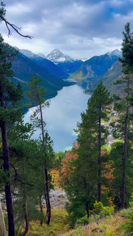  Plansee lake among snow-capped mountains in Tyrolean Alps, Austria late autumn in cloudy weather. High quality 4k footage