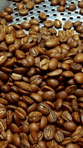 Vertical screen: Roasted vietnamese coffee bean. Fragrant coffee beans scrolls slowly around the camera. Slow Motion Close Up of Whole Roasted Coffee Beans.High angle view. Shot for Social Media