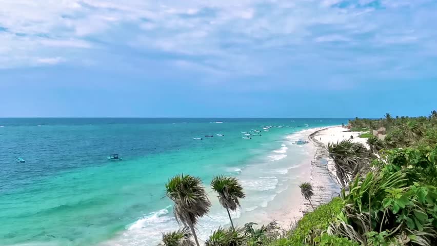 Playa Santa Fe tropical paradise beach panorama view with white sand turquoise blue water and green palm trees in Tulum Quintana Roo Mexico.