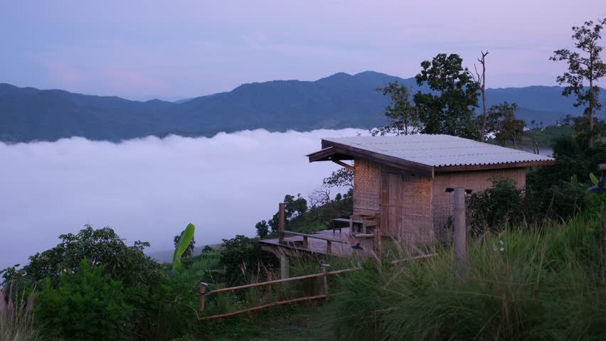 A wooden house with the sea of fog and mountain view at dawn