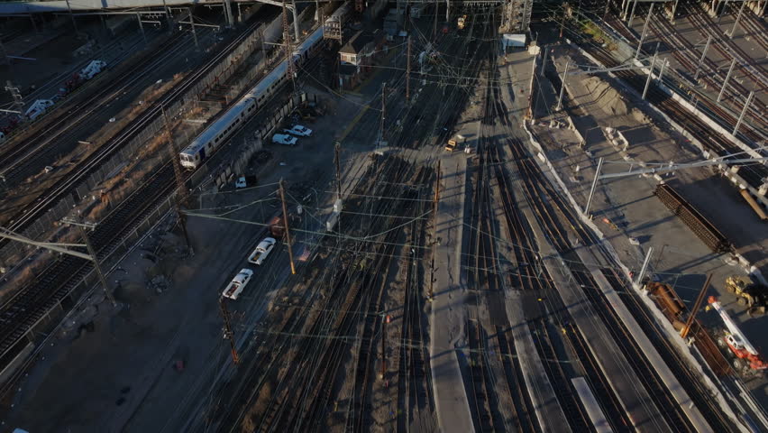 Aerial view showcasing Sunnyside Yard's expansive railroad networks, maintenance vehicles, and transportation infrastructure across Queens urban landscape