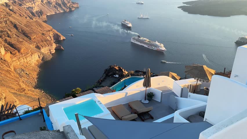 Beautiful sunset in Santorini island, Greece. White architecture with sea view. Blue sea and the blue sky at sunset. Panoramic view. Summer travel and vacation. 
