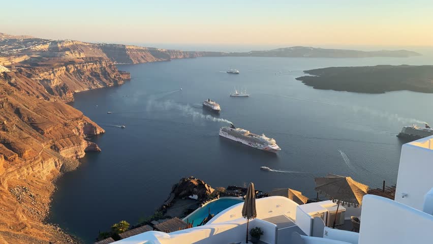 Beautiful sunset in Santorini island, Greece. White architecture with sea view. Blue sea and the blue sky at sunset. Panoramic view. Summer travel and vacation. 
