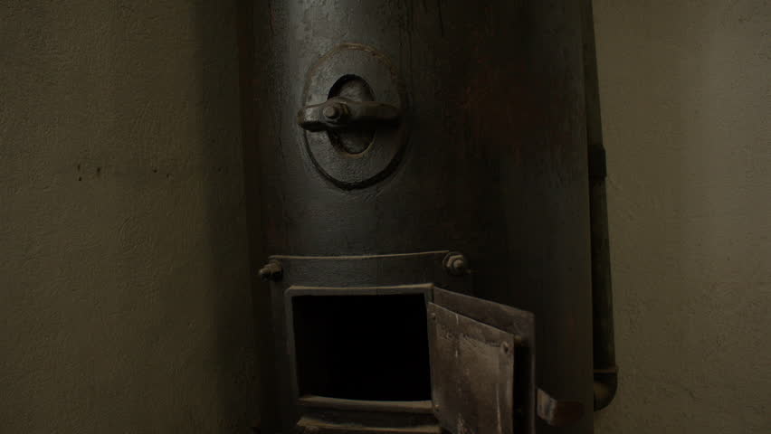 A close-up of an old black furnace door with locking mechanisms and latch. Furnace in former concentration camp Natzweiler-Struthof , now a museum