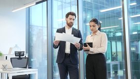 Professional business meeting between two financiers in modern office, discussing important documents with focus collaboration on work project. Colleagues consult about details, busy with paperwork - Powered by Shutterstock - Get 15% off with code: PIKWIZARD15