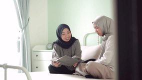 two moslem female sibling learning read smile happy together bedroom home - Powered by Shutterstock - Get 15% off with code: PIKWIZARD15