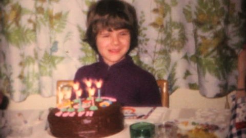 MOOSIC, PENNSYLVANIA, 1968: A cute little girl enjoys blowing out the candles at her birthday party in 1968.