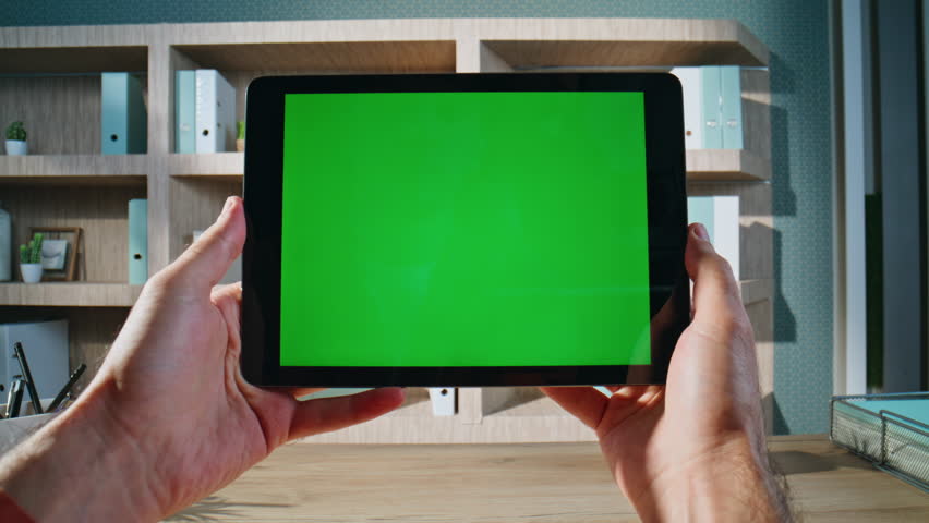 Tablet user holding chroma key display working online at modern workplace closeup. Unknown businessman reading message on green screen pad computer. Office manager browsing video at mockup device. - Powered by Shutterstock - Get 15% off with code: PIKWIZARD15