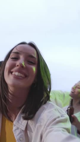 Vertical point of view of a happy caucasian woman bringing her boyfriend towards a rooftop party. Unrecognizable man following a pretty lady towards the dance floor.