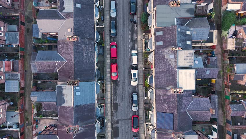 Aerial drone reveal footage of rows of tightly packed back to back residential terraced houses in a large inner city housing estate in the UK