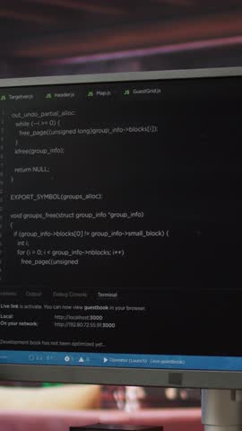 Vertical video Computer desk with coding application on monitor used for creating software, implementing algorithms. Code editor on PC display used to build applications in cozy bright living room