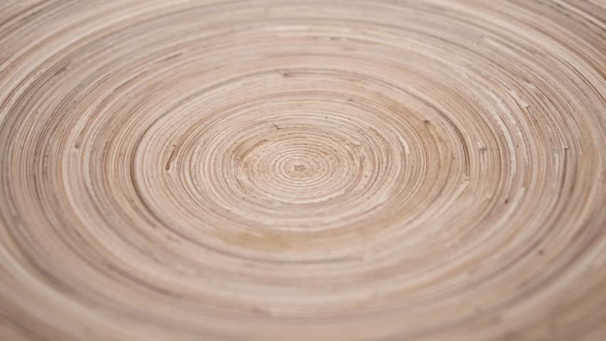 A mesmerizing close-up of circular wooden patterns, showcasing the natural texture and intricate concentric details. Round wooden fruit plate