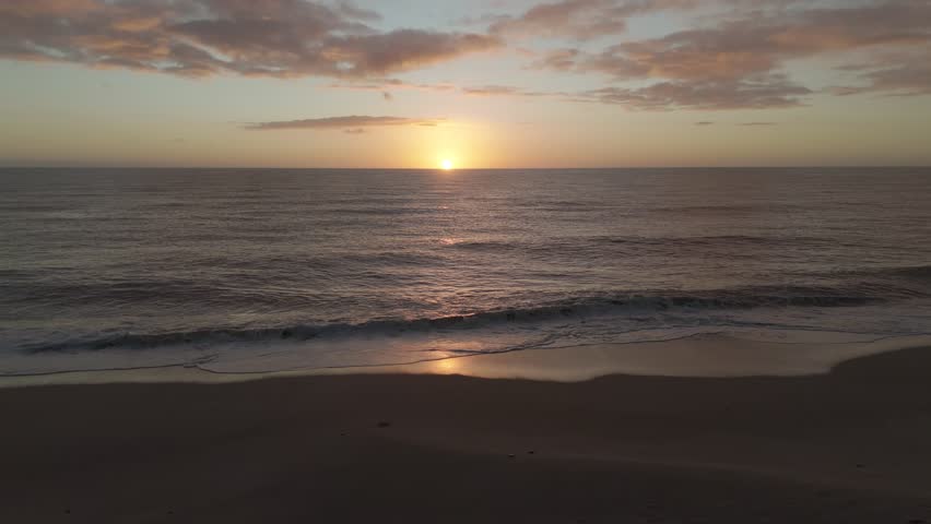 Drone aerial view of a sunrise on a beach near Peniscola in Spain.