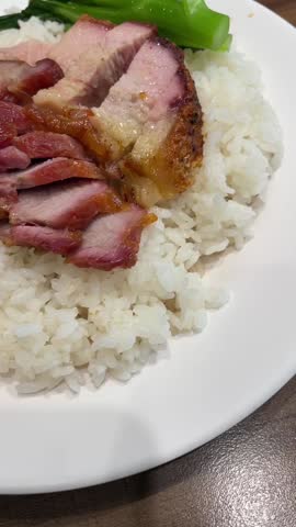 Up close view of Char Sui Chinese bbq pork over rice and with veggies.