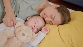 A single Asian mother lovingly cares for and raises her baby boy at home. Attractive mother shares a tender moment, spend leisure time sleep with her newborn in warm and nurturing family environment. - Powered by Shutterstock - Get 15% off with code: PIKWIZARD15