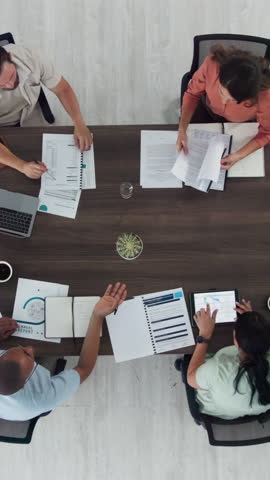 People, meeting and accounting with paperwork, discussion or review for progress with tech in office. Men, women and above with documents, feedback or planning in team with financial report at agency