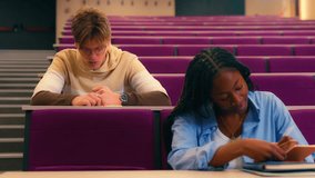 Diverse university students intently writing notes during lecture, capturing academic focus and collaborative learning in slow motion educational setting - Powered by Shutterstock - Get 15% off with code: PIKWIZARD15